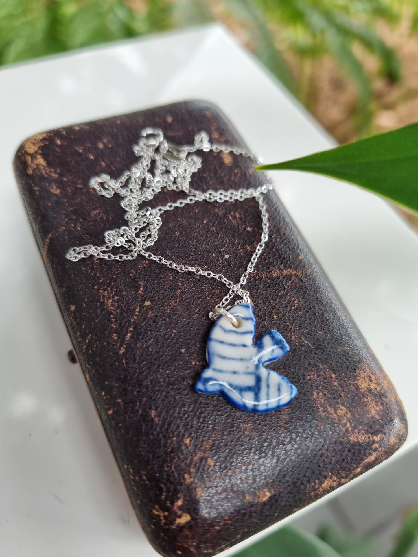 Italian sterling silver necklace with a delicate ceramic bird pendant.